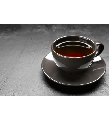 Кружка чая с блюдцем на сером фоне